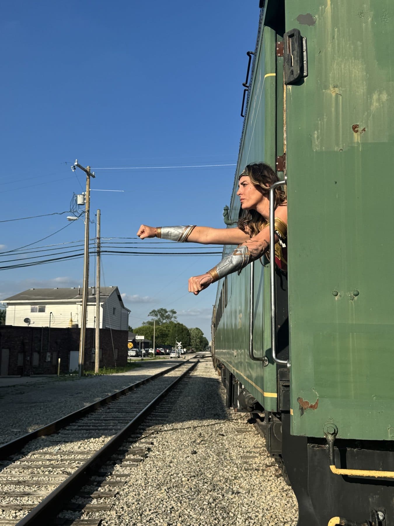 Mid-leap off a concrete wall against a clear blue sky.