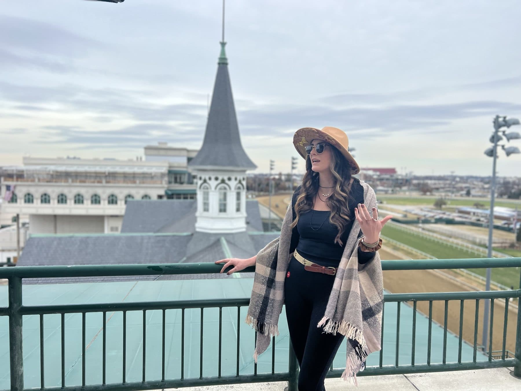 Plaid wrap on a balcony, Churchill Downs spires behind.