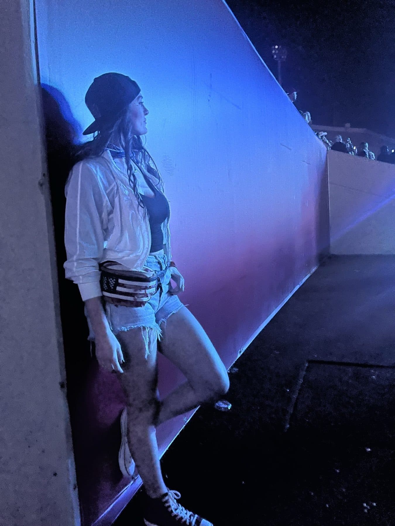 Reclining on a ledge under blue light.