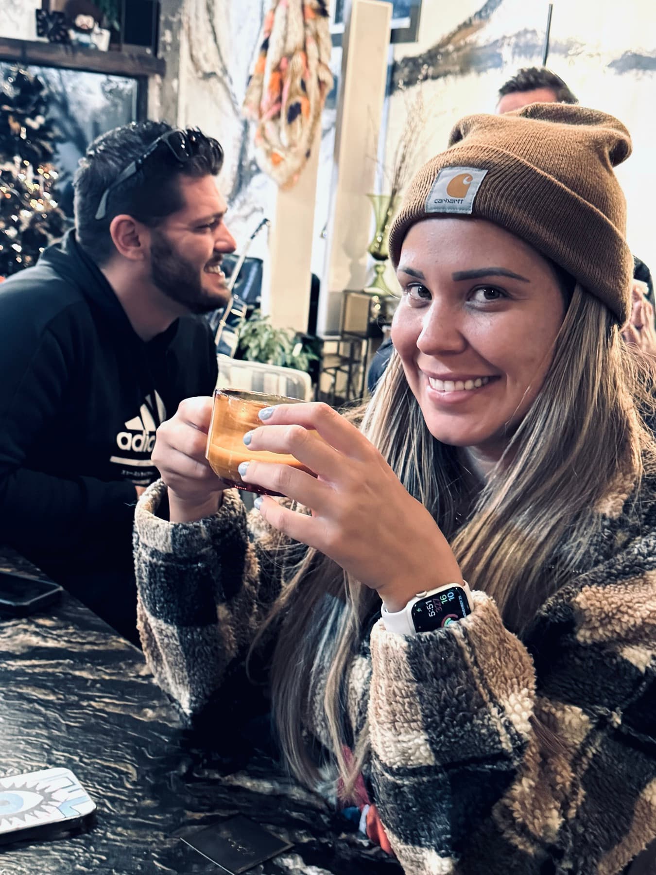 A couple laughing together over drinks, caught candid and warm.