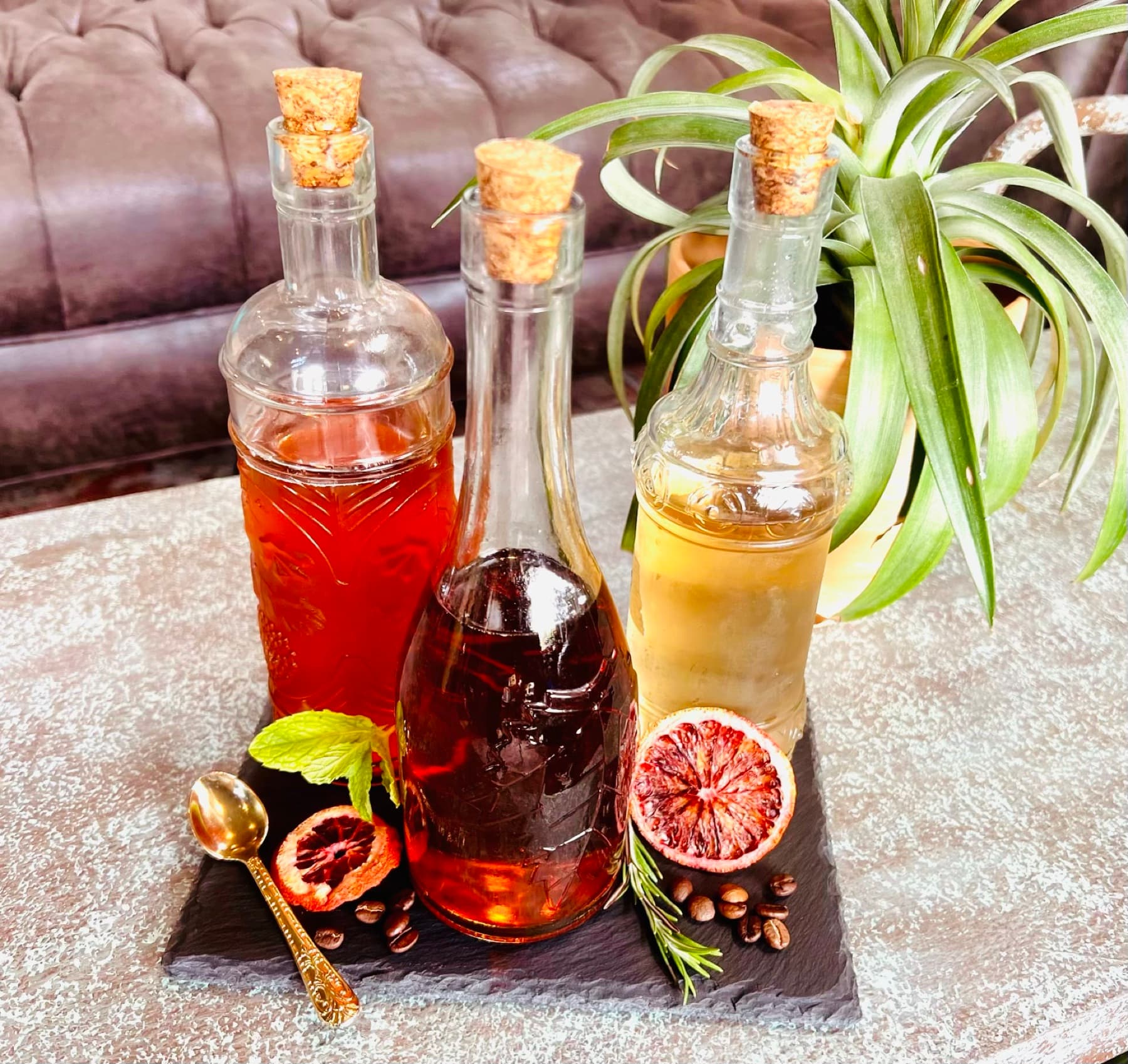 Cherry-and-citrus mocktail bottles styled with fresh fruit.