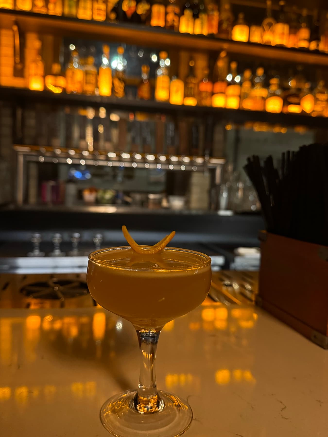 Amber pours lined up along a backlit bar.