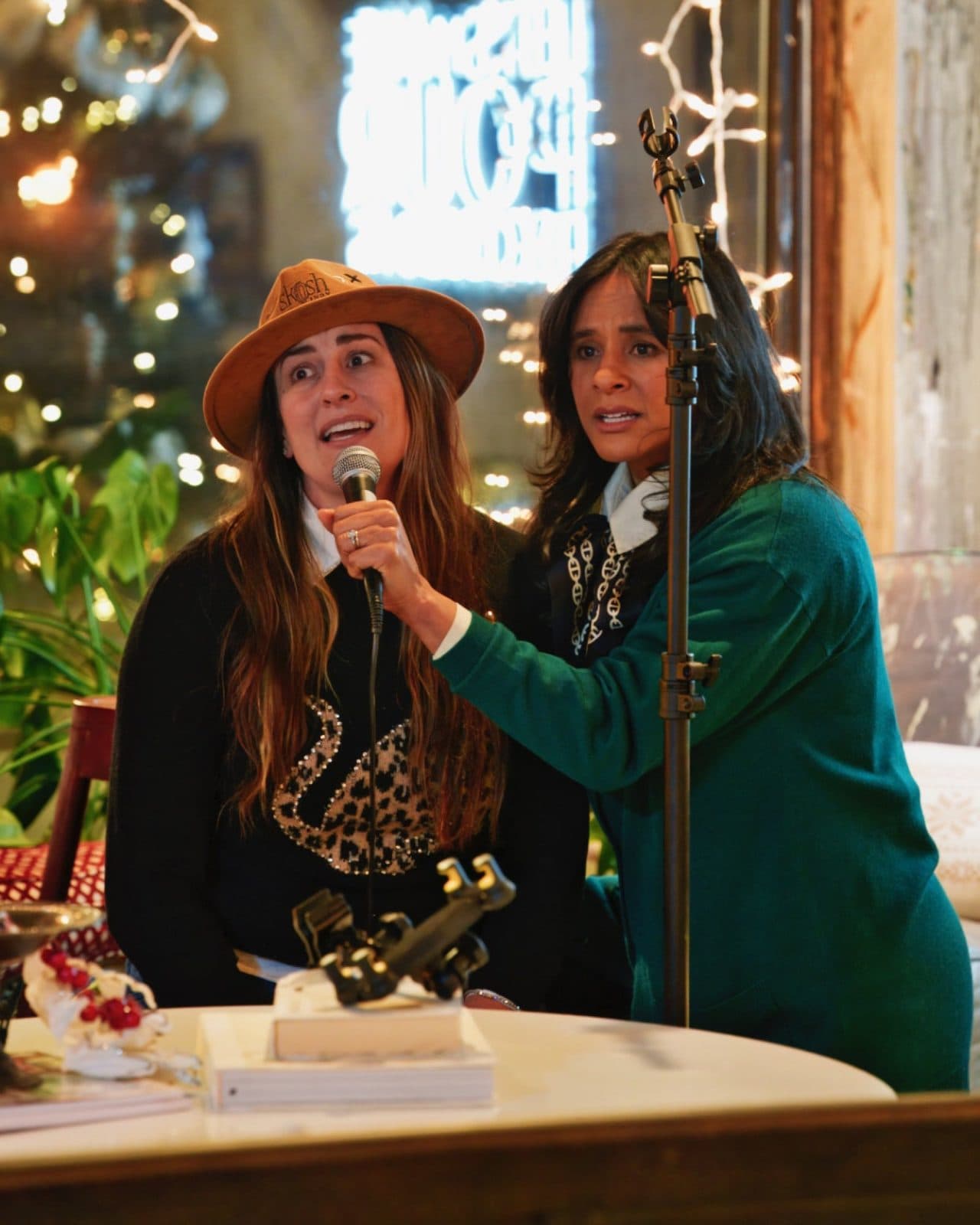 Haley on the mic at a porch party, string lights and a bandmate beside her.