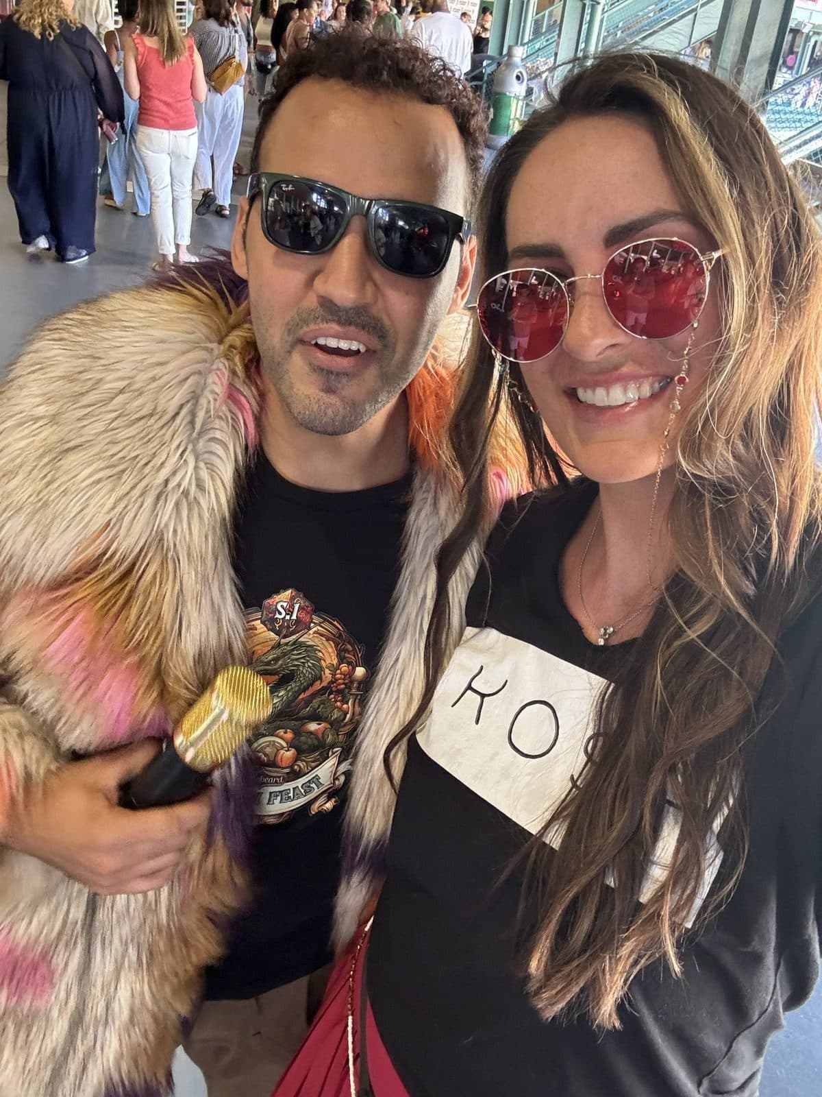 Two guests in a faux-fur coat and Skōsh tee, sunglasses on, close to the camera.