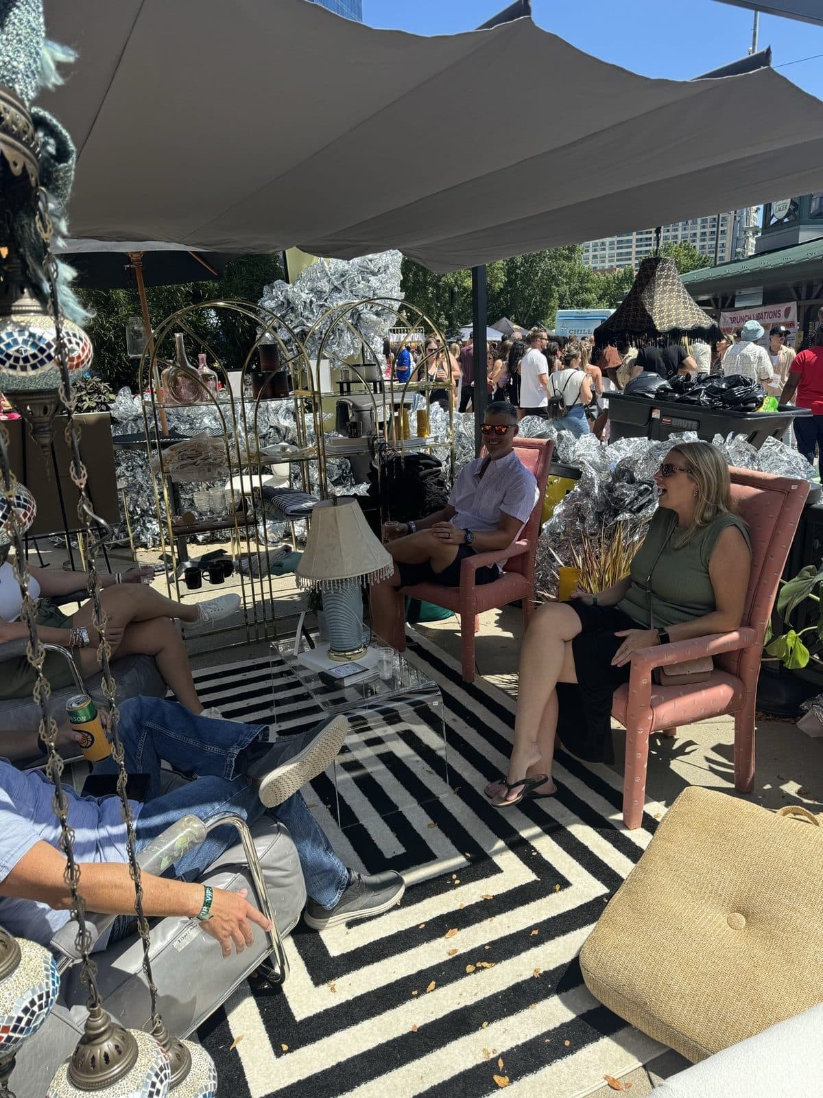 Guests settled into the shaded lounge on a black-and-white chevron rug, a pink chair and silver-foil balloons behind.