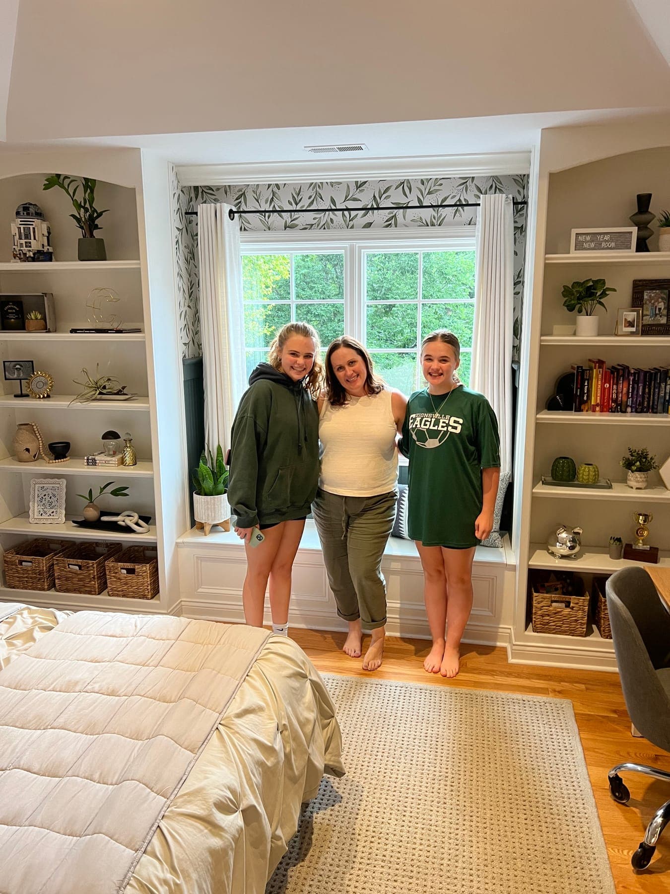 Haley with the two sisters in front of the finished window seat and built-ins, botanical curtains and plants on every shelf.
