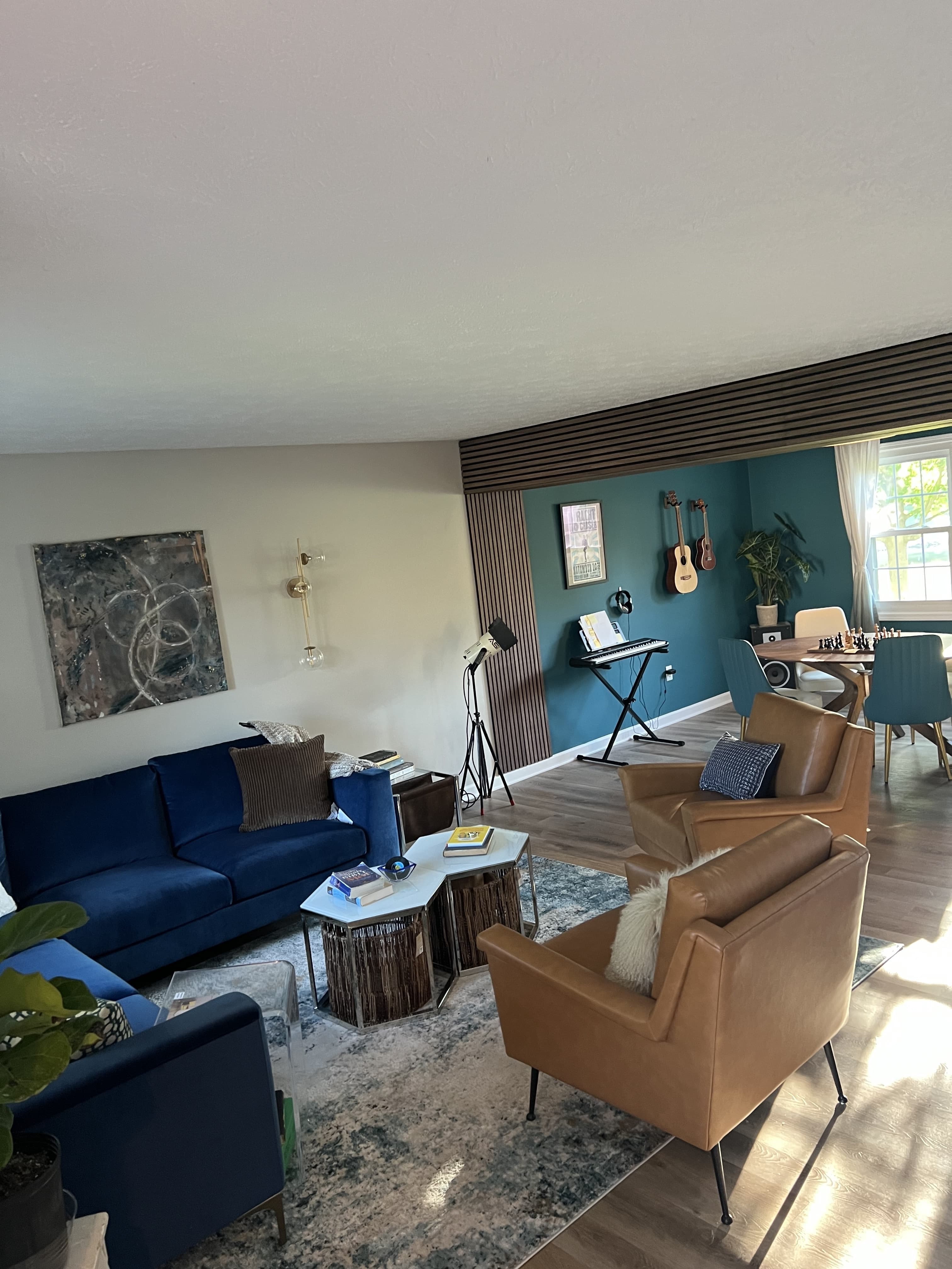 The navy sofa and gallery wall, with the music studio and dining table beyond.