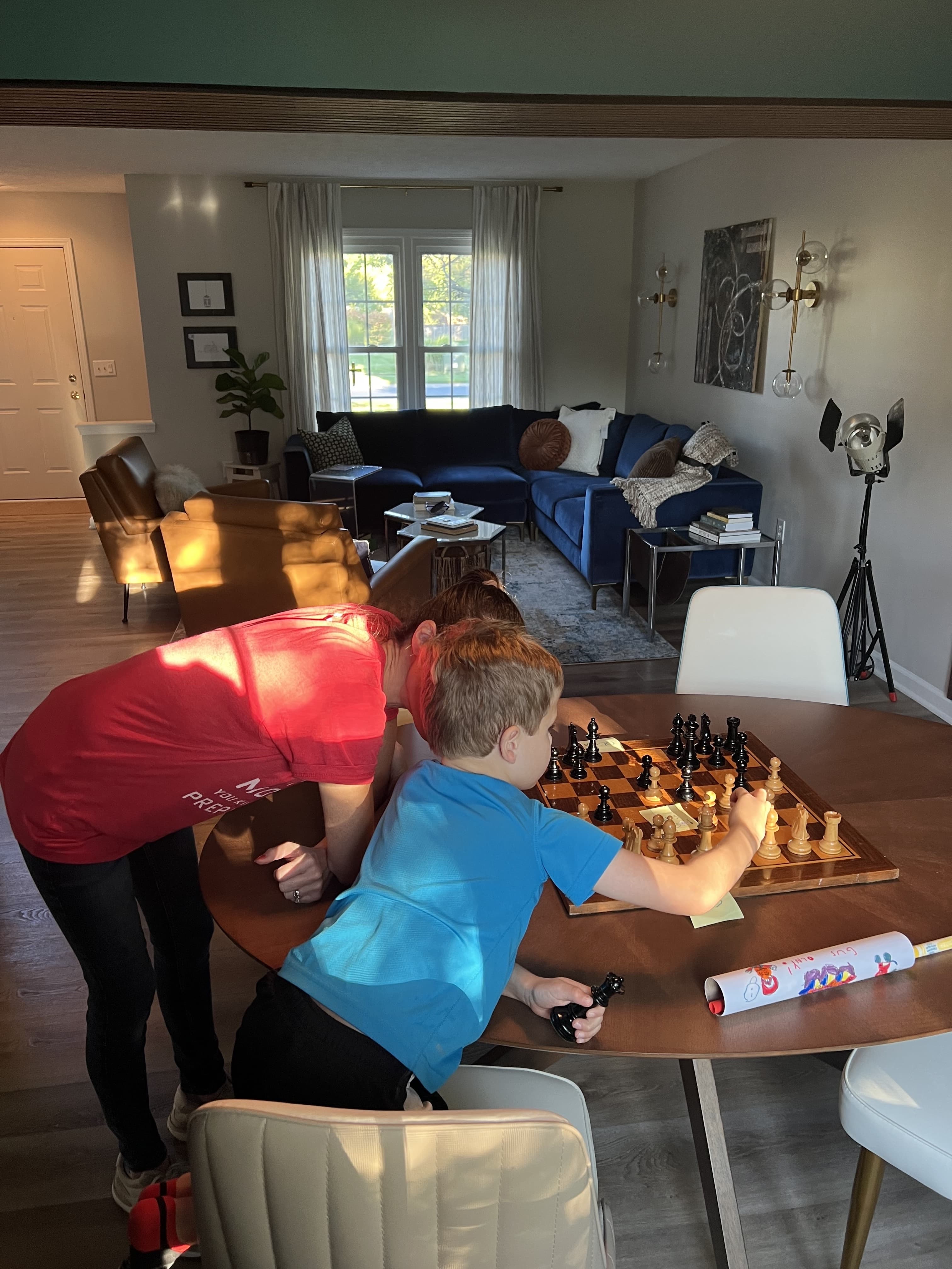 Kids playing chess at the round dining table in the finished living room.