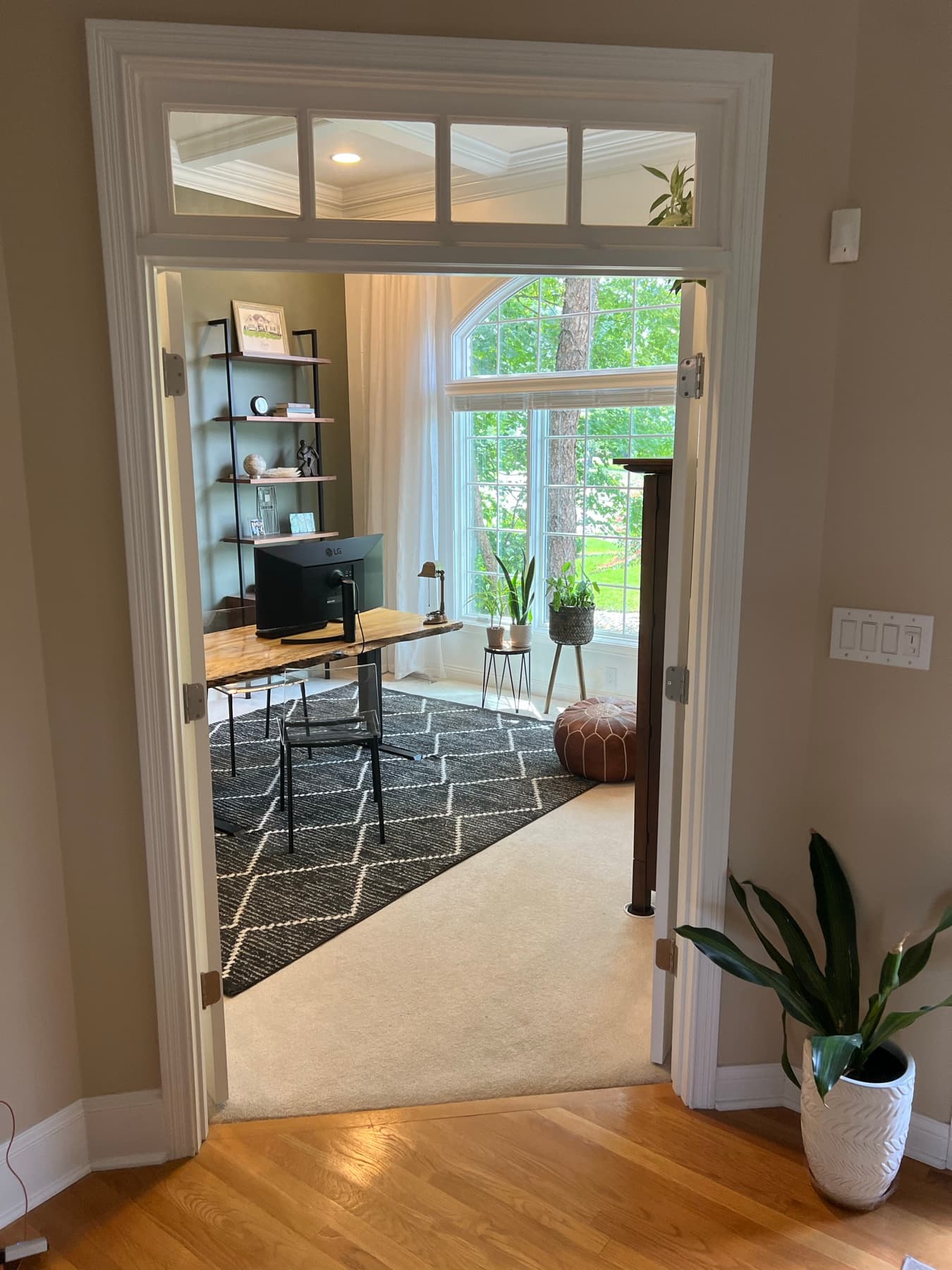 Greenery cascading over open shelving by the window.