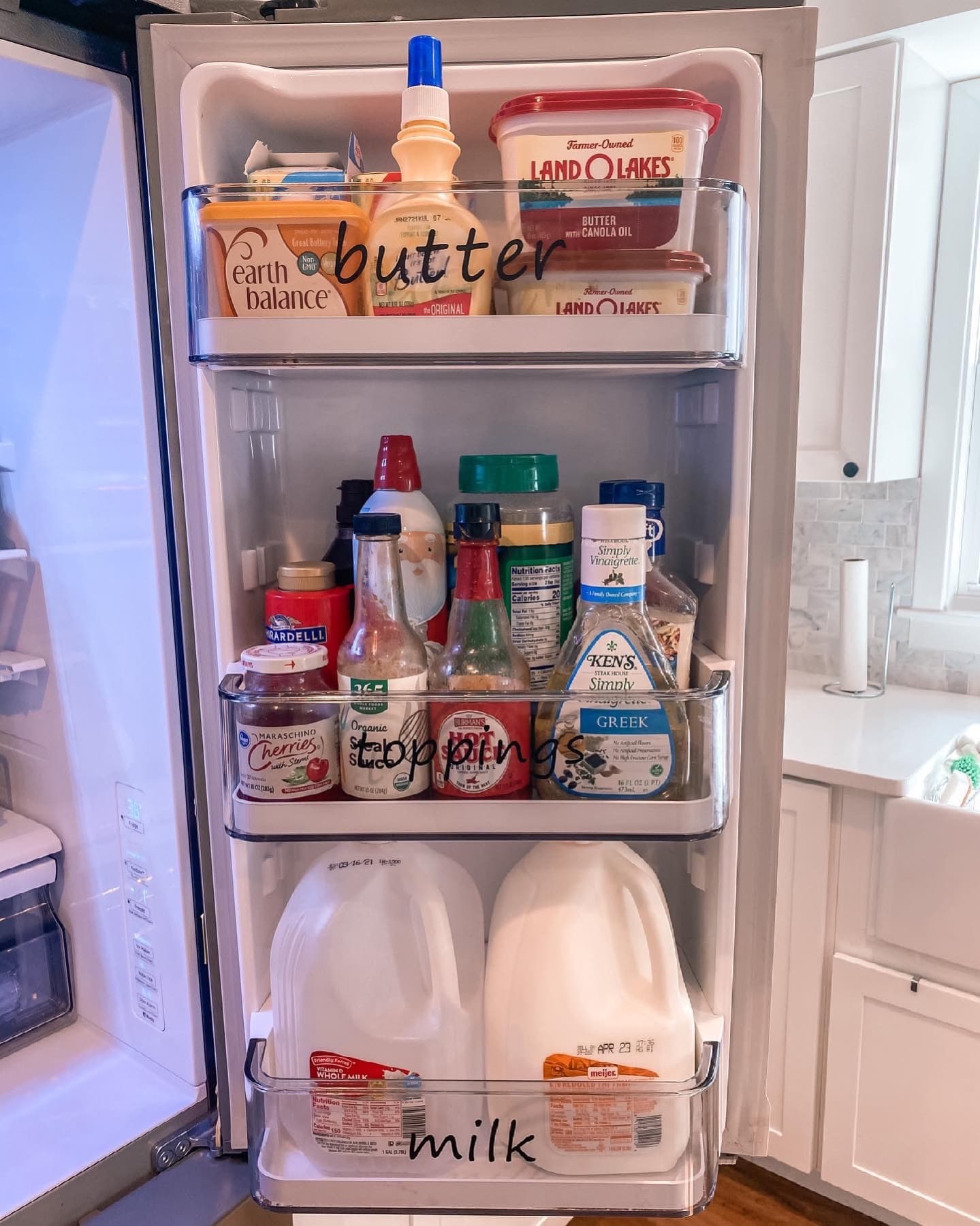 The fridge zoned with labeled clear bins.
