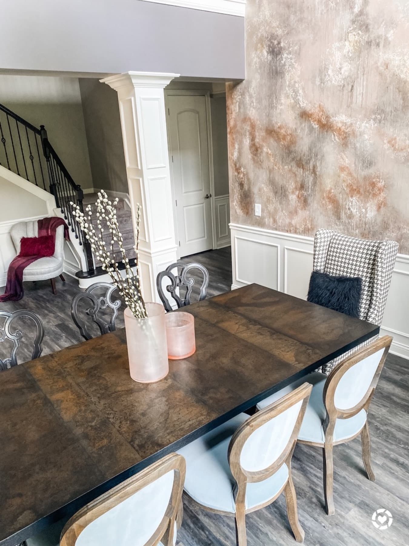 The table set under the chandelier, stone wall behind.